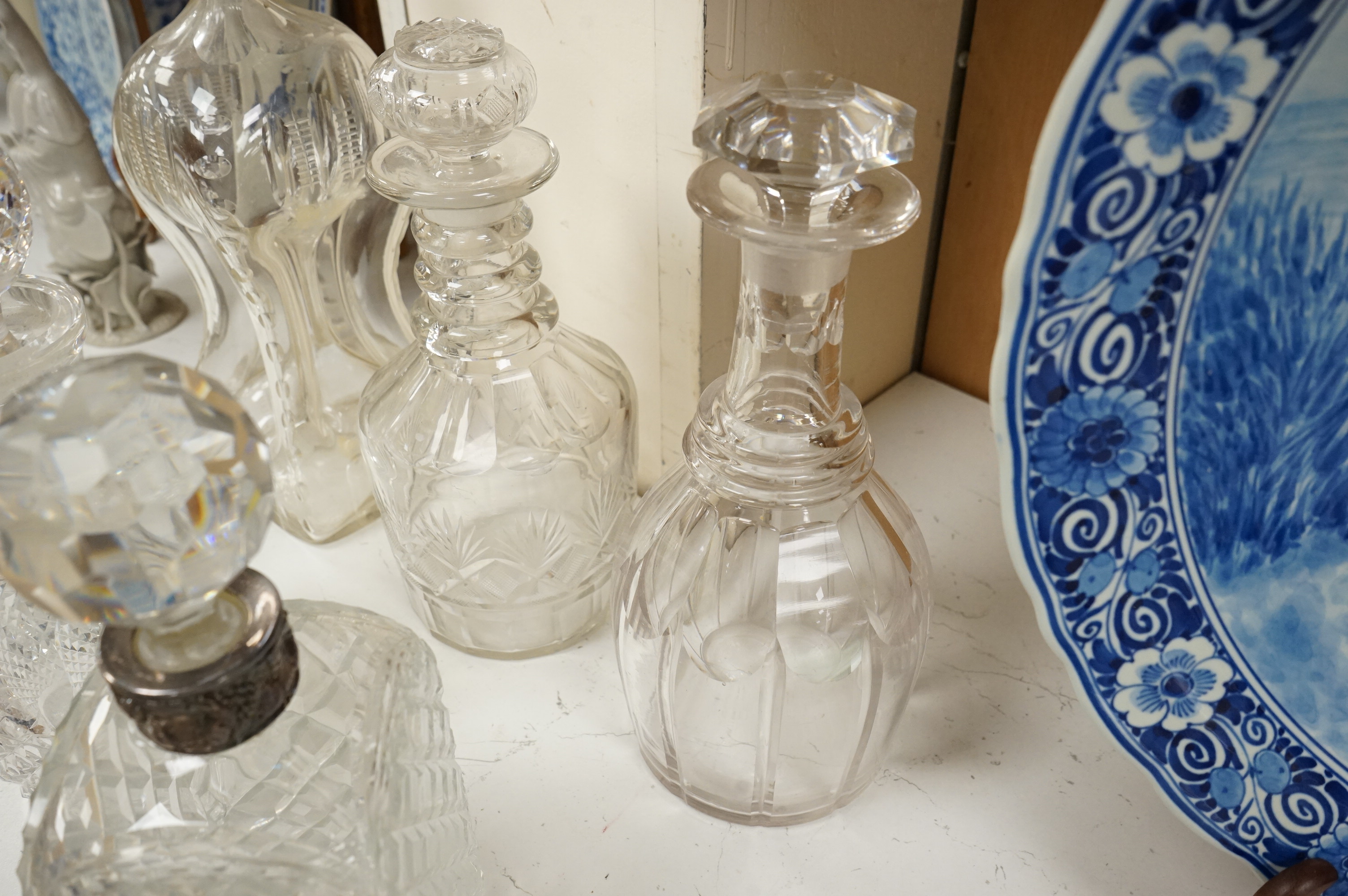 Six 19th century and later cut glass decanters and stoppers, one with white metal acorn design collar, largest 37cm high